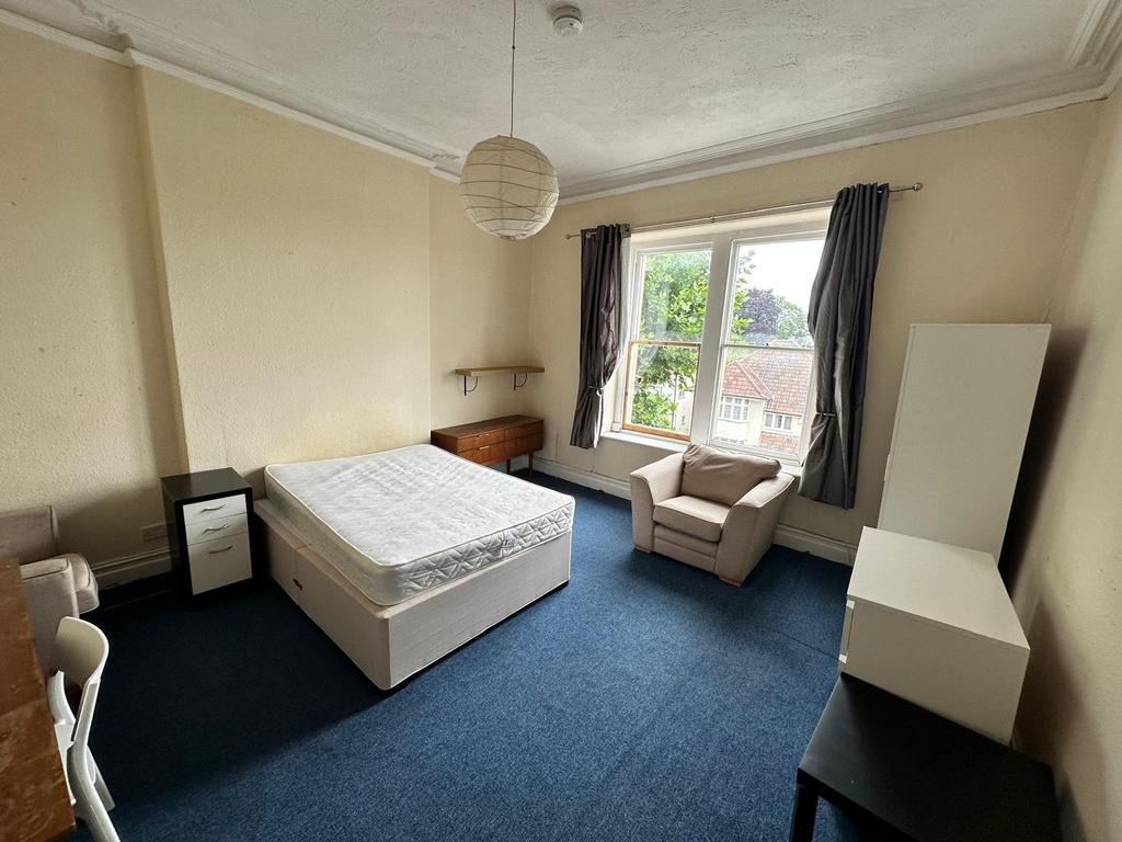 Bright double bedroom with a large sash window ...