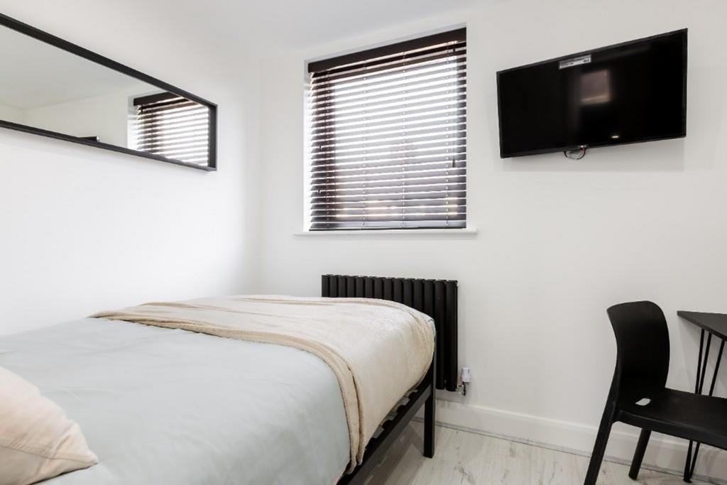 A bright and tidy double bedroom featuring mode...