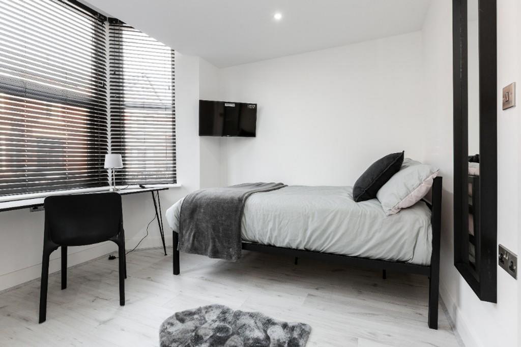 A bright and modern double bedroom with a comfo...