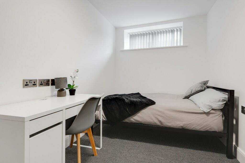 A tidy and inviting single bedroom featuring a ...