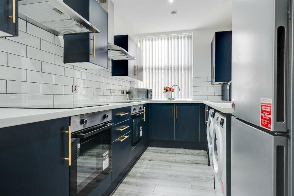 A modern and tidy kitchen with ample light, per...