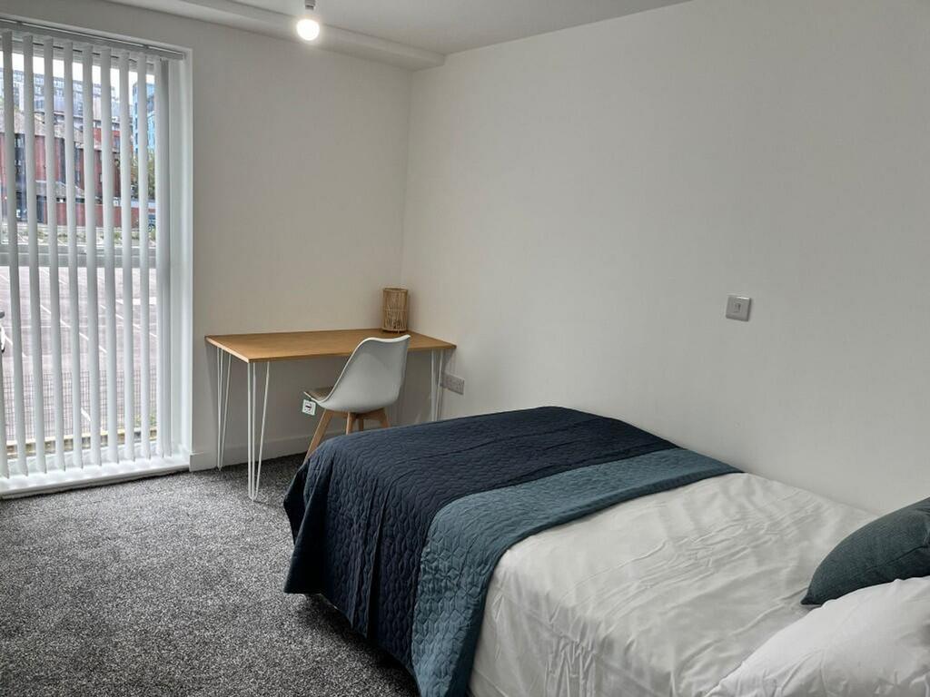 A bright and tidy double bedroom featuring a co...