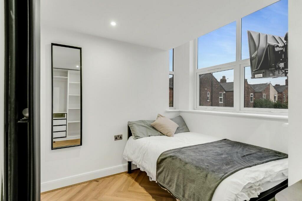 This stylish double bedroom features large wind...