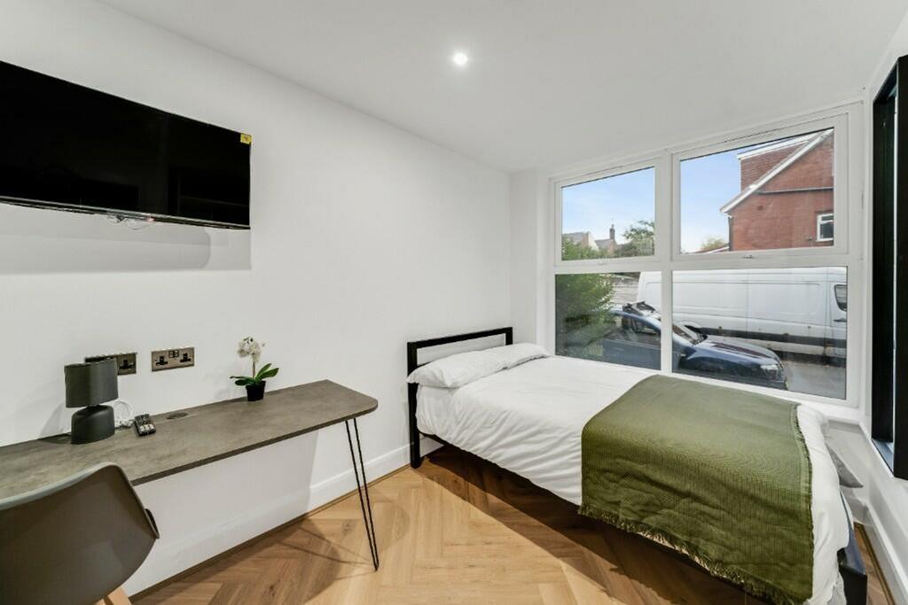 Bright and modern double bedroom featuring larg...