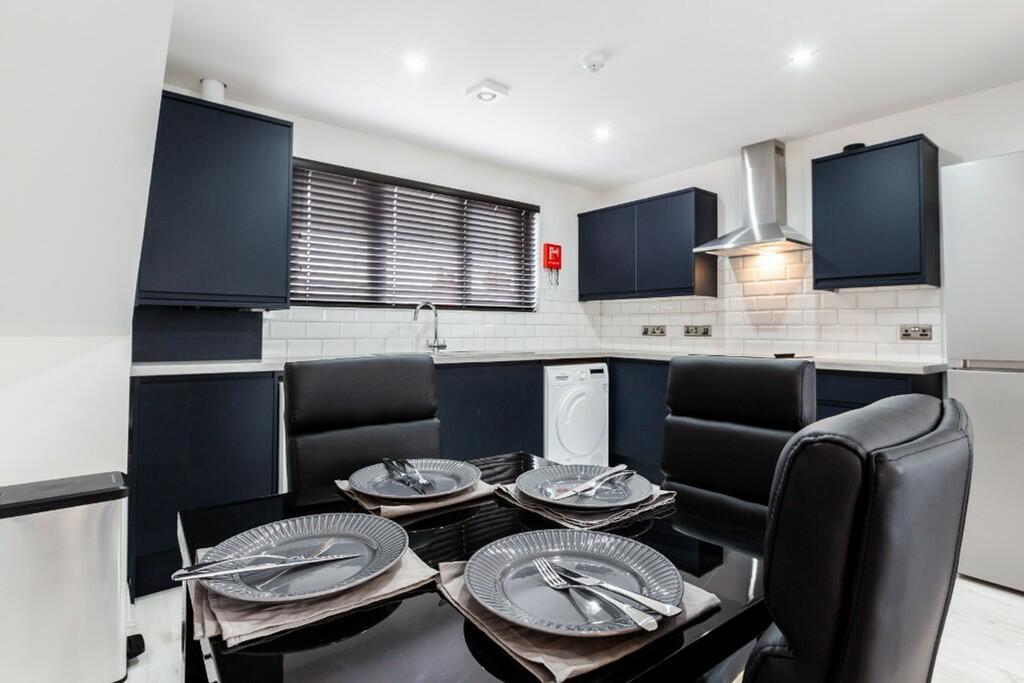 Modern kitchen featuring sleek dark cabinetry a...