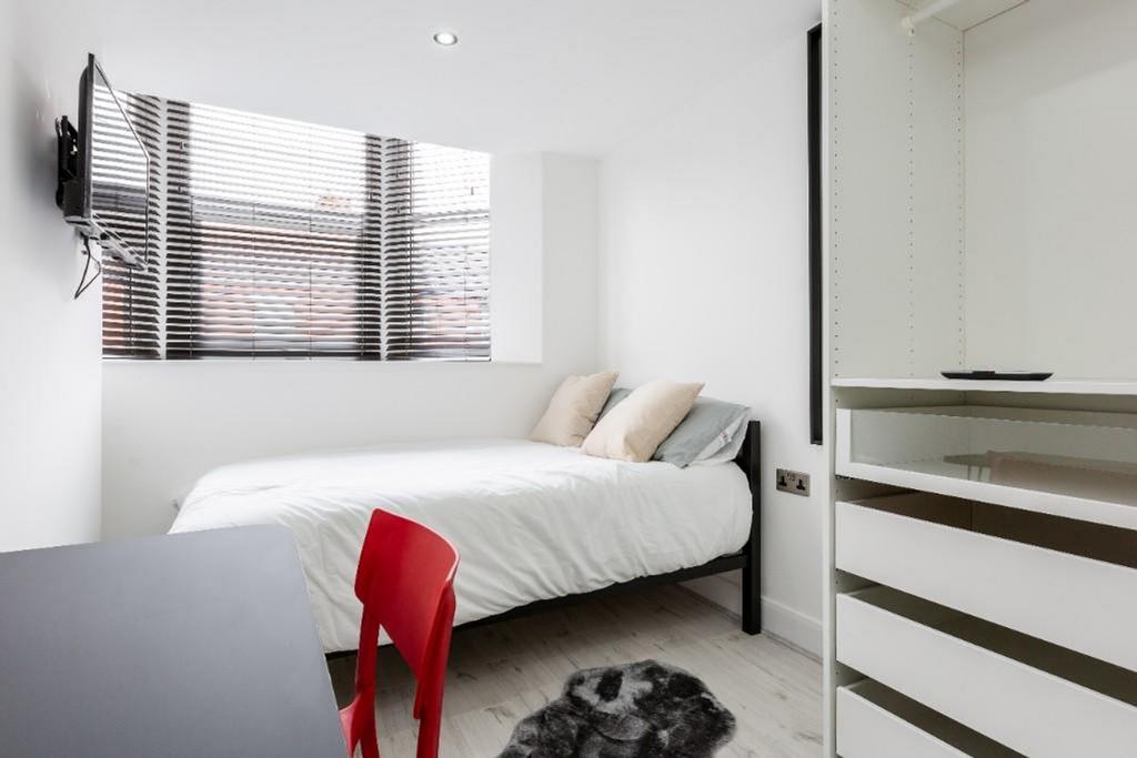 A bright and modern double bedroom featuring st...