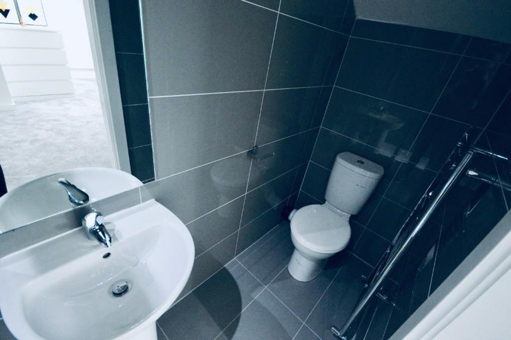 A modern and tidy bathroom featuring sleek tile...
