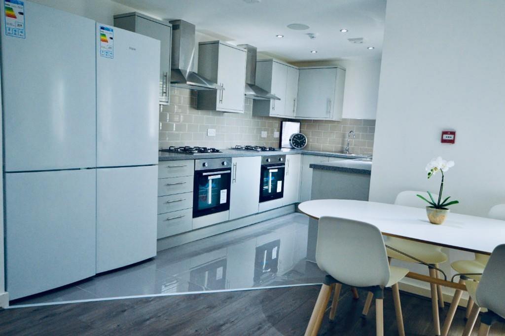 A modern and spacious kitchenette, featuring sl...