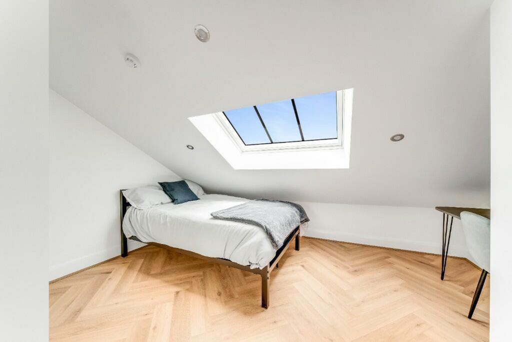 This charming double bedroom features a cozy de...