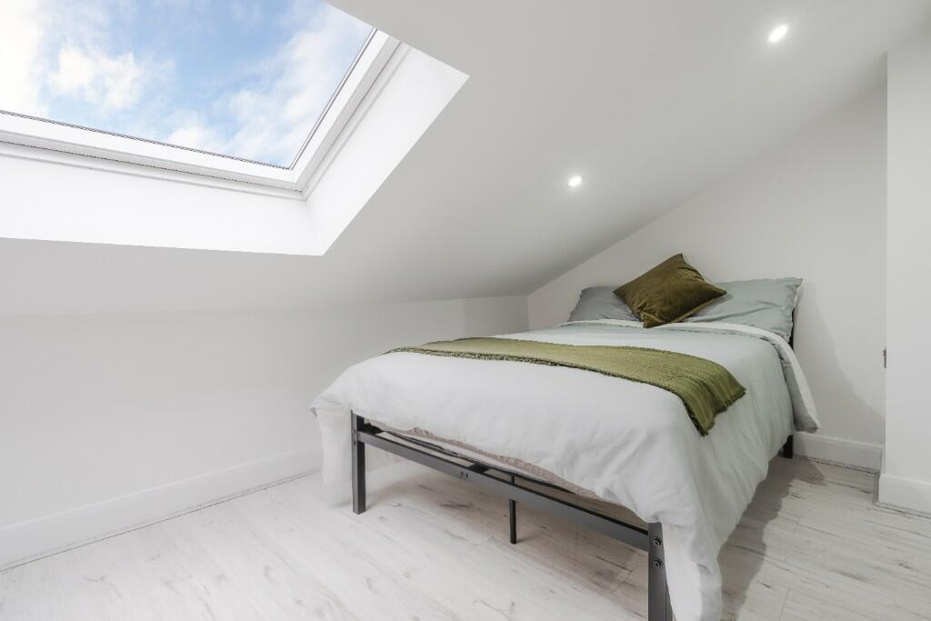 This cozy double bedroom features a comfortable...