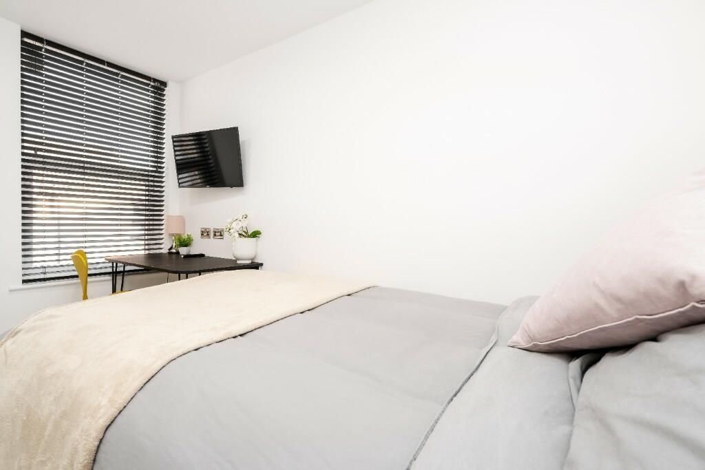 This inviting double bedroom features a cozy at...