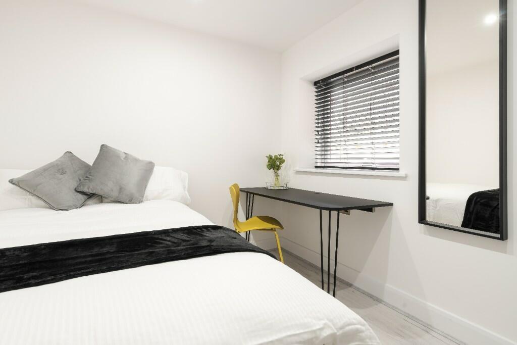 This charming double bedroom features a cozy at...