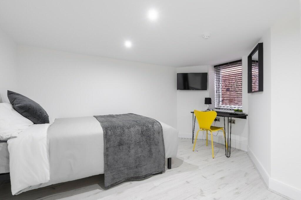 This stylish double bedroom features a comforta...