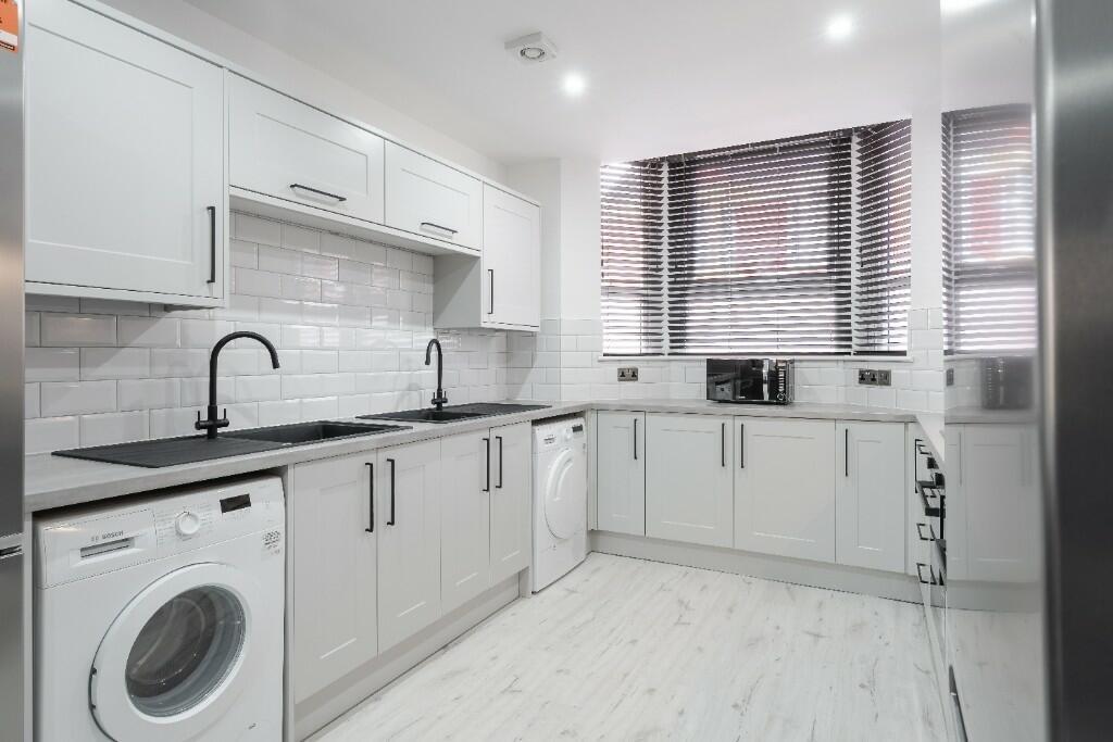 This modern kitchen features ample cabinetry, d...