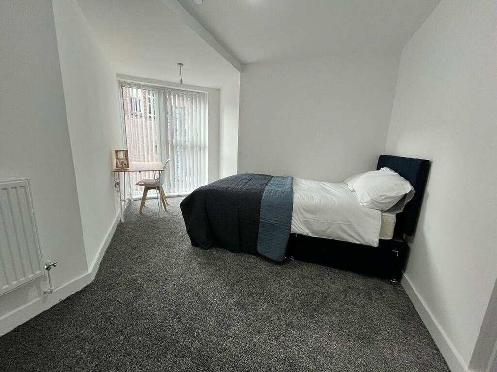 A bright and spacious double bedroom with moder...