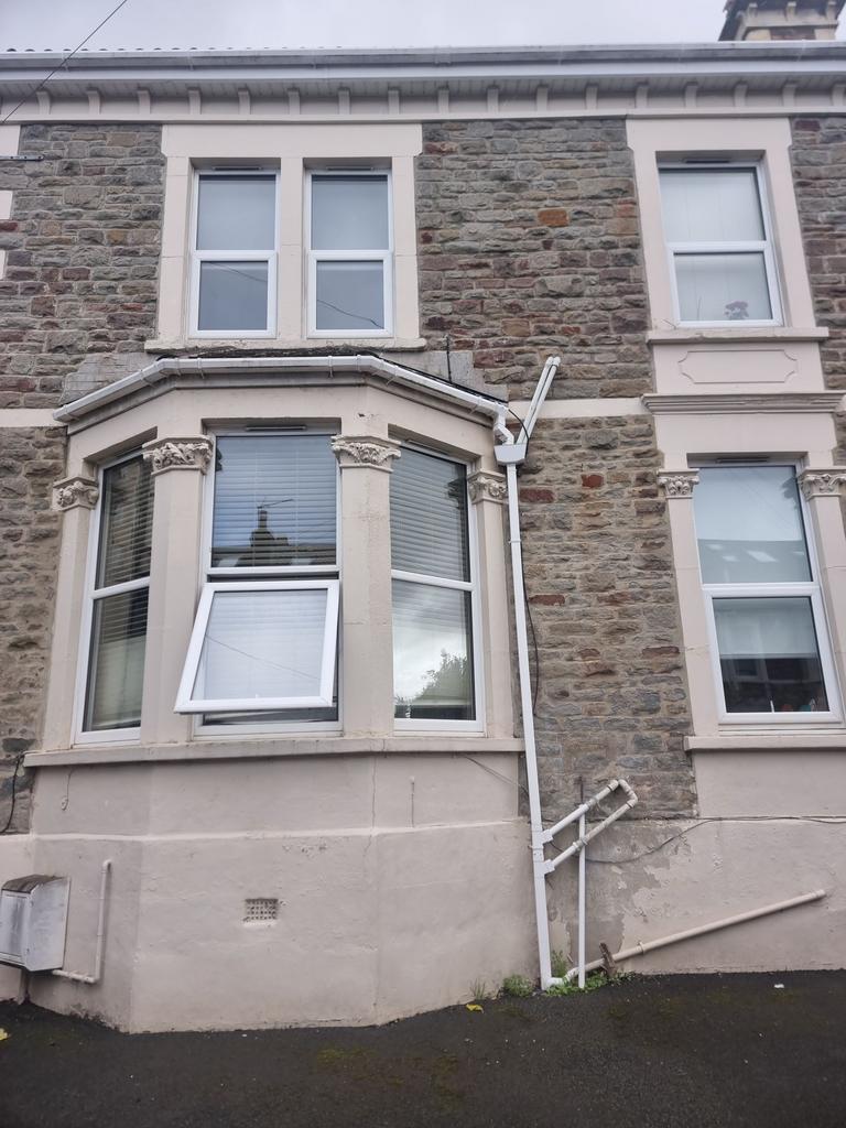 Stone-fronted terraced house with a bay window,...