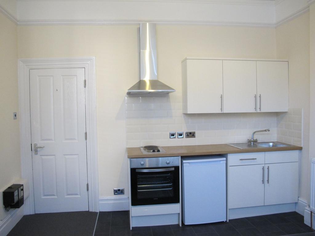 Bright, modern kitchenette with white cabinets,...