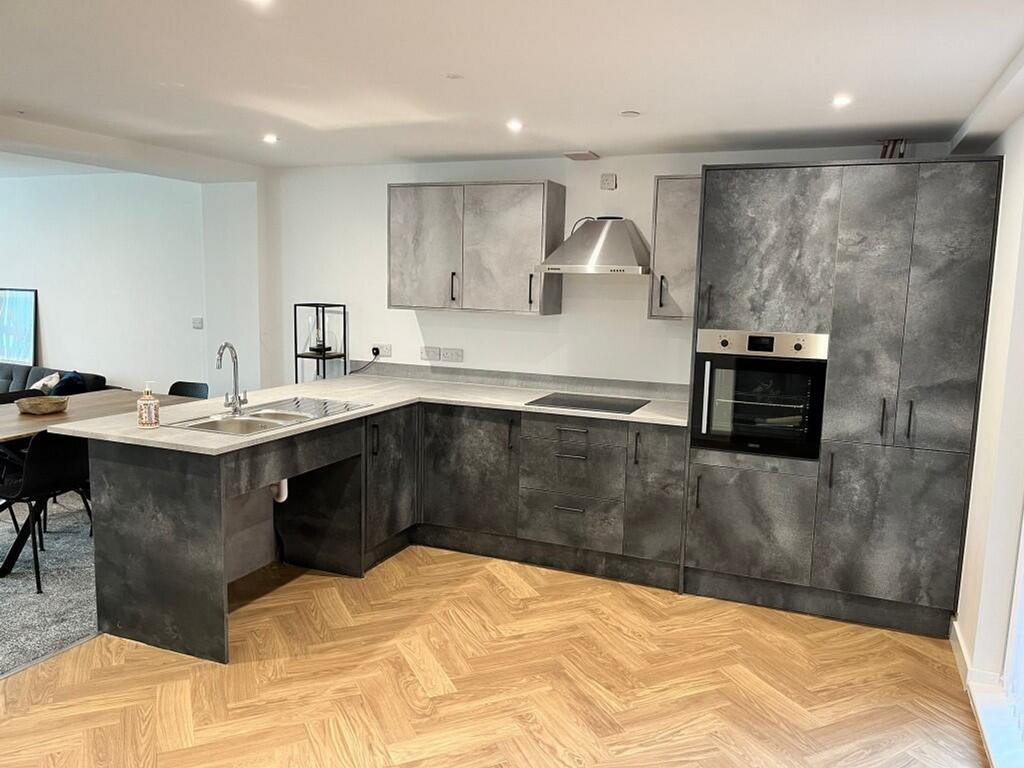 A modern and spacious kitchenette featuring sty...