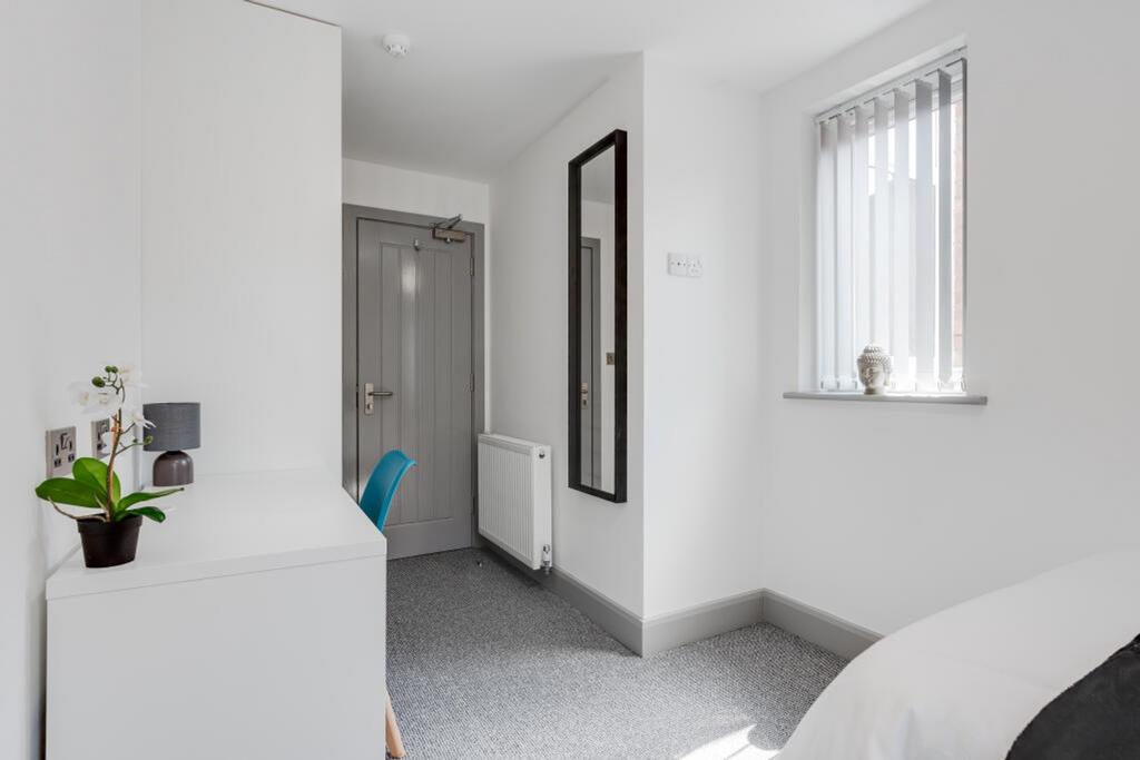 A bright and tidy double bedroom featuring mode...
