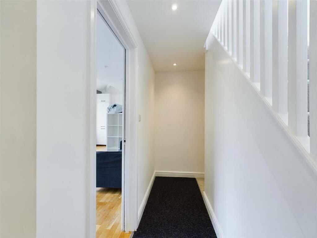 A bright and tidy hallway leading to inviting l...