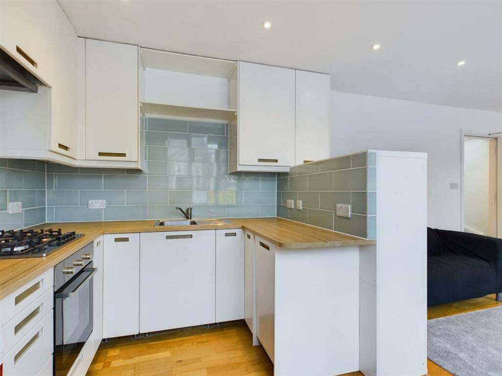A modern kitchenette featuring sleek cabinetry ...