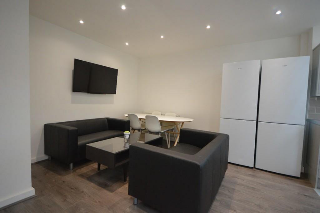 A modern living room featuring sleek black sofa...