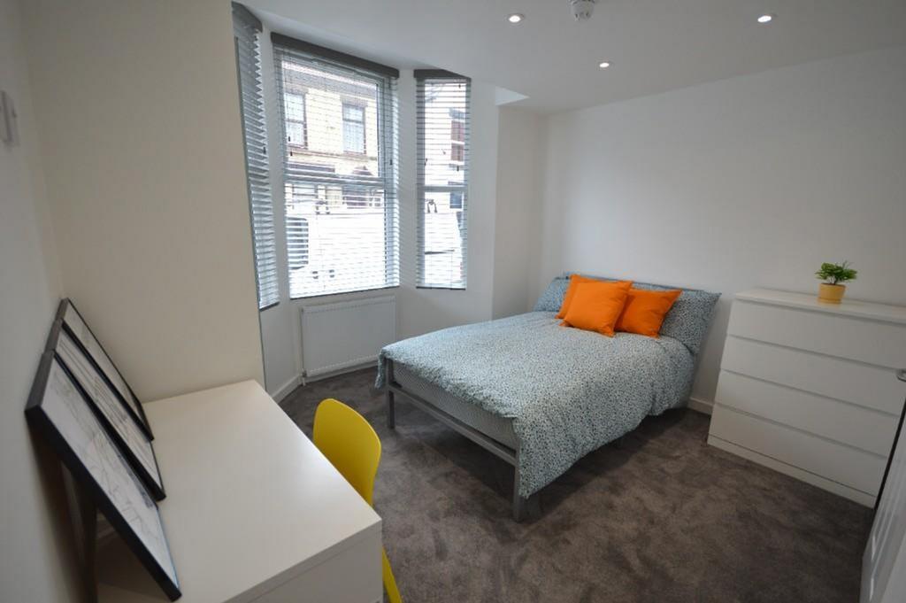 Bright and cozy double bedroom featuring modern...