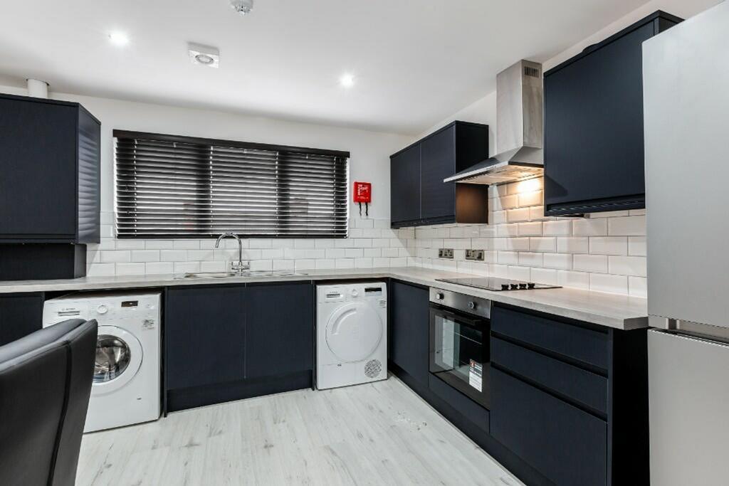 Modern kitchen featuring sleek cabinetry, ample...