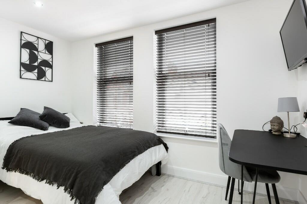 This inviting double bedroom features large win...