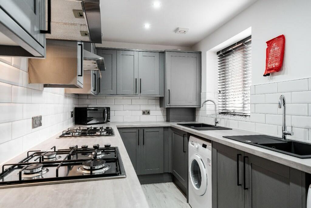 Modern kitchen featuring sleek grey cabinetry, ...
