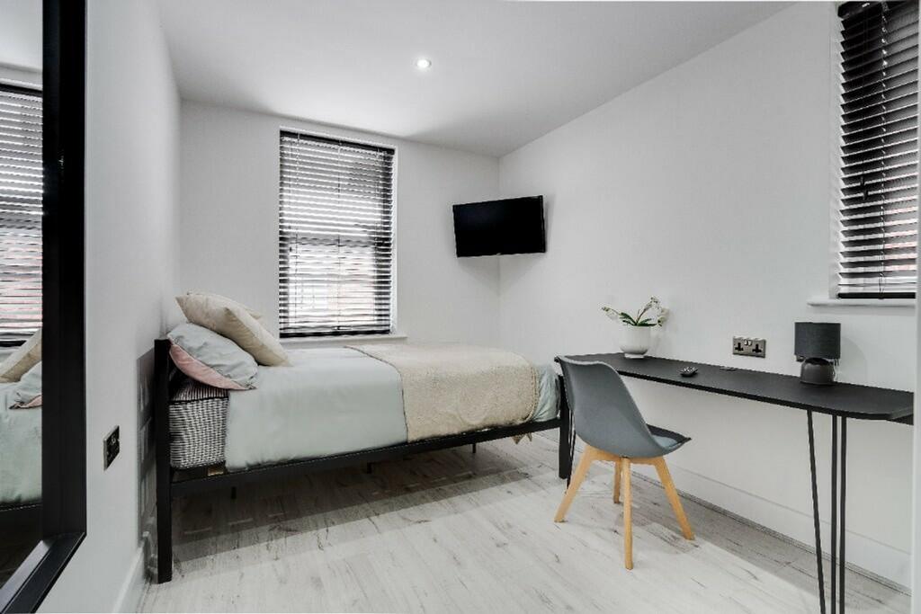 This stylish double bedroom features a comforta...