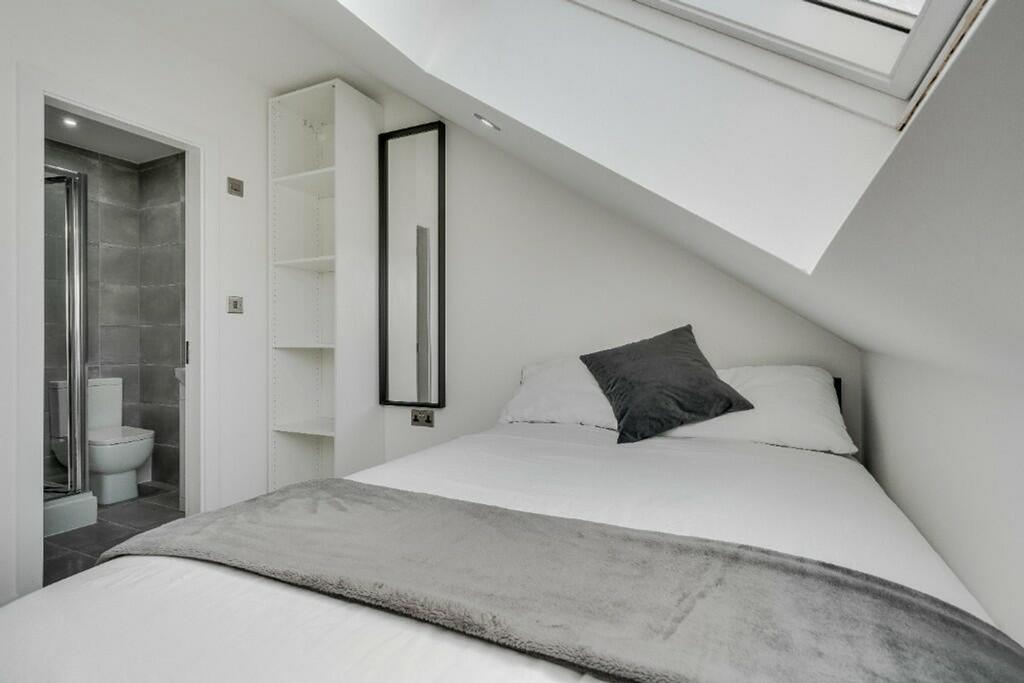 This stylish double bedroom features a comforta...