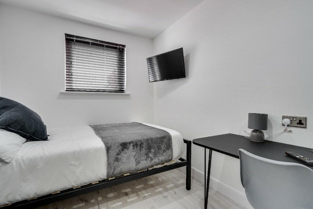 This modern double bedroom features a comfortab...