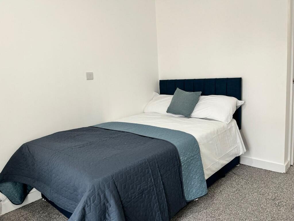 A bright and tidy double bedroom featuring mode...