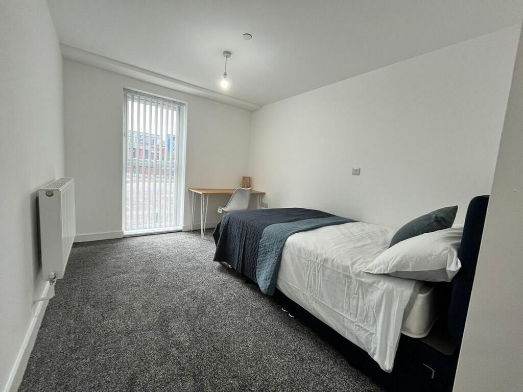 A spacious and bright double bedroom with moder...