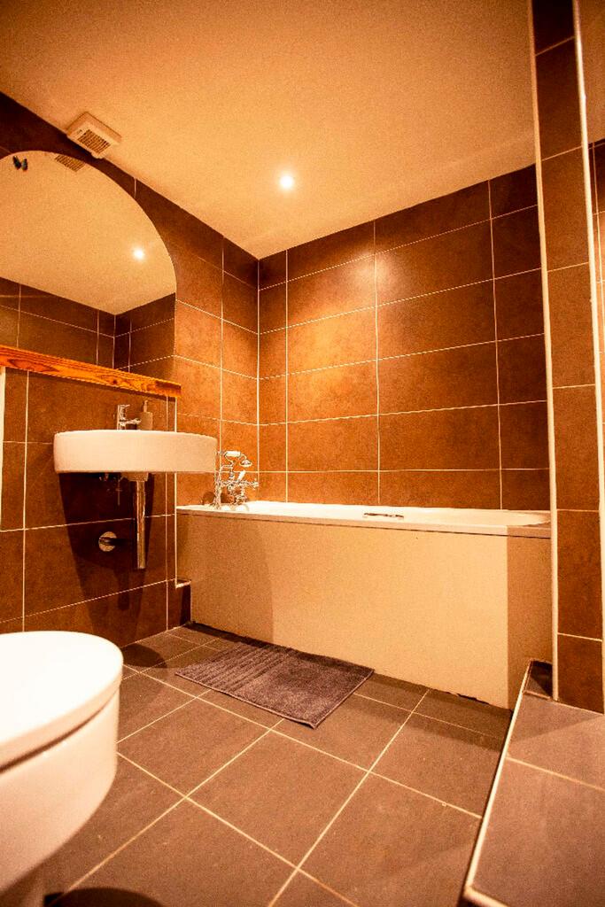 A spacious and modern bathroom featuring a rela...