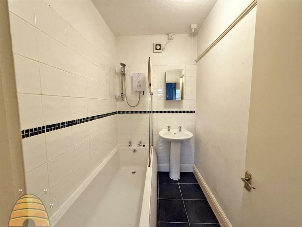 A clean and modern bathroom featuring a bathtub...