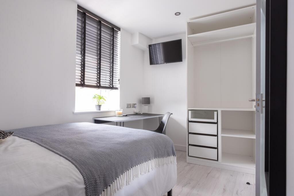 A cozy double bedroom featuring modern furnishi...