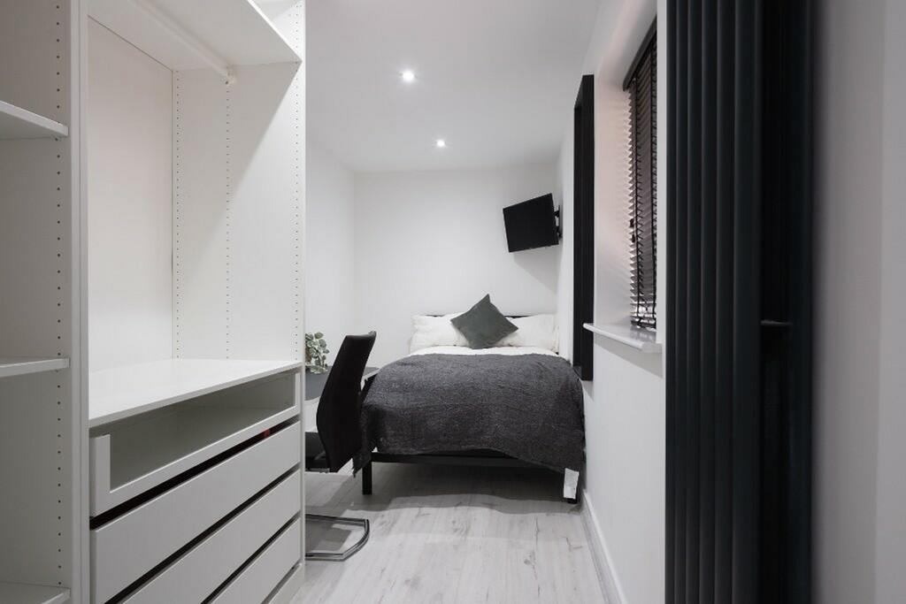 A modern double bedroom featuring a cozy bed, s...