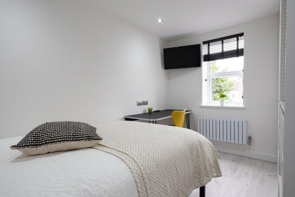 This stylish double bedroom features a comforta...