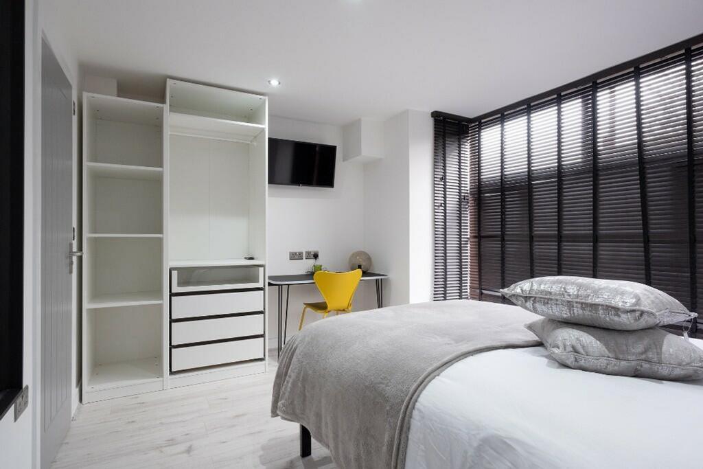 This stylish double bedroom features a contempo...