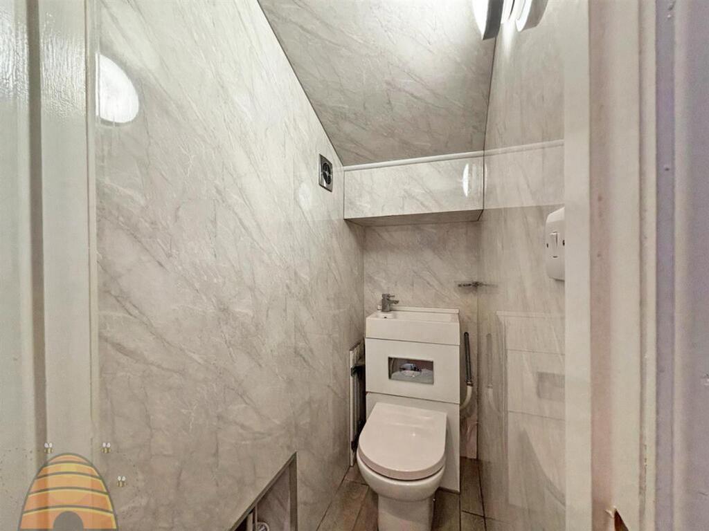 A modern single toilet featuring elegant marble...