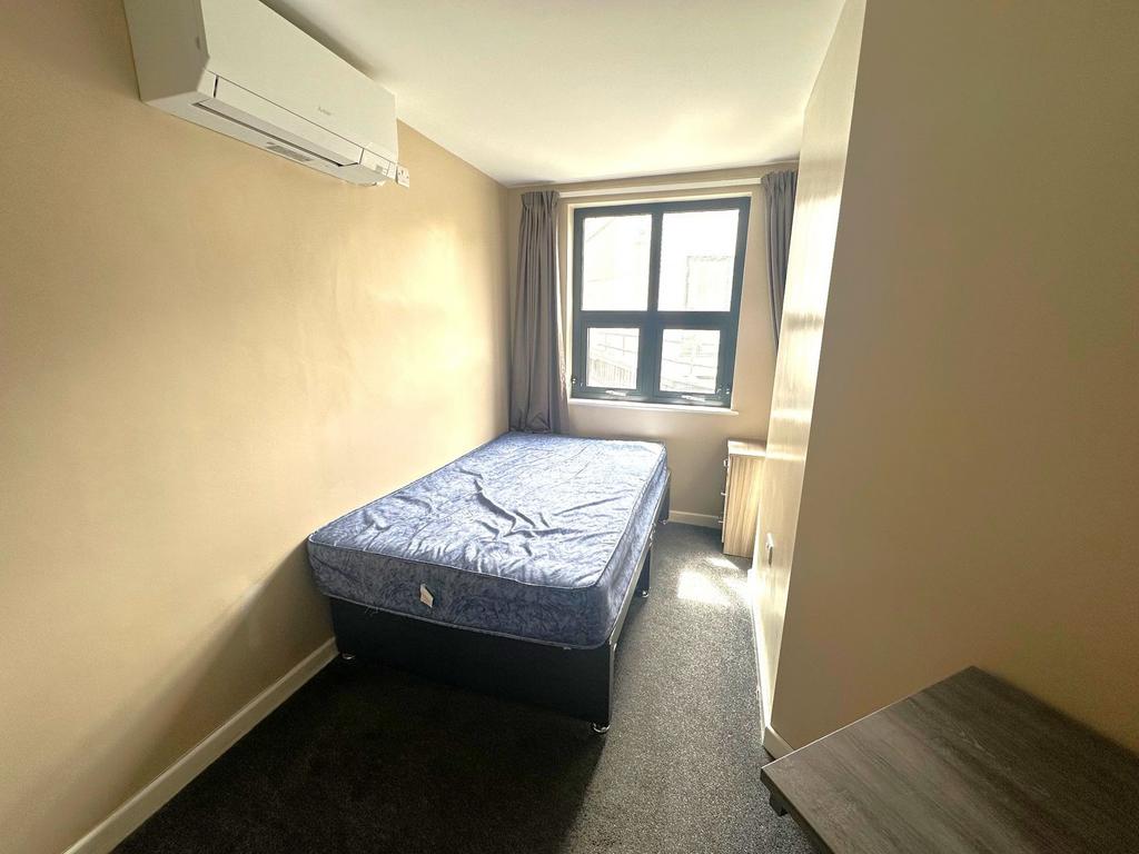 Bright, simply furnished single bedroom with a ...