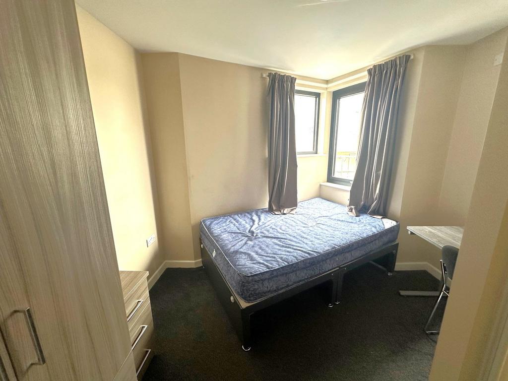 Bright double bedroom with a raised double bed ...