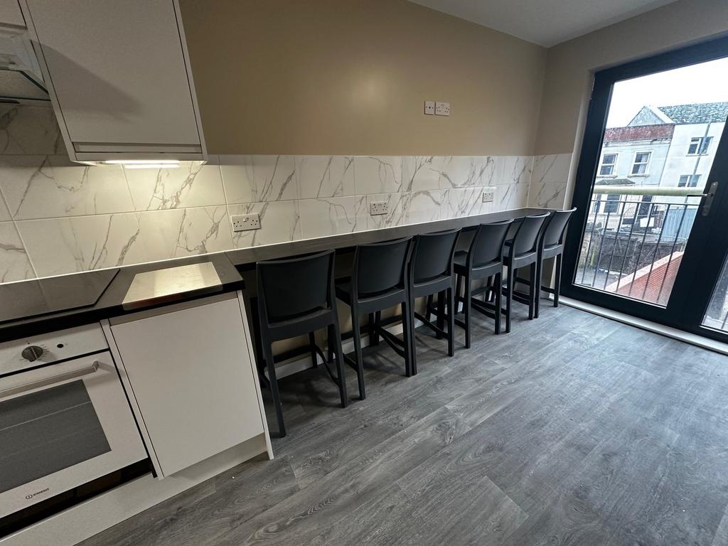 A modern kitchen featuring sleek cabinetry, sty...