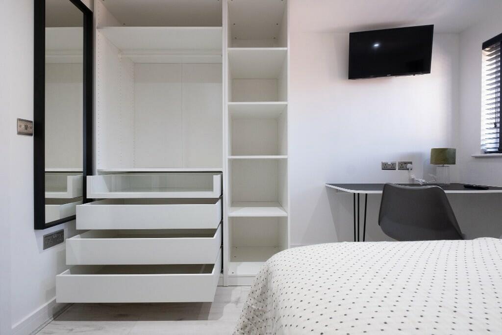 A modern and well-organized double bedroom feat...