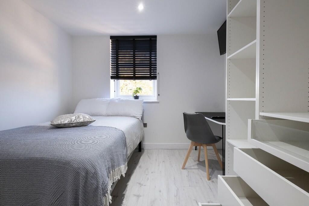 A clean and modern double bedroom featuring a c...