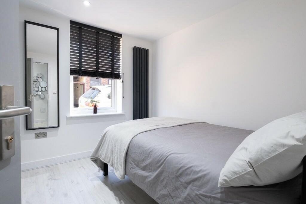 A bright and tidy double bedroom featuring mode...