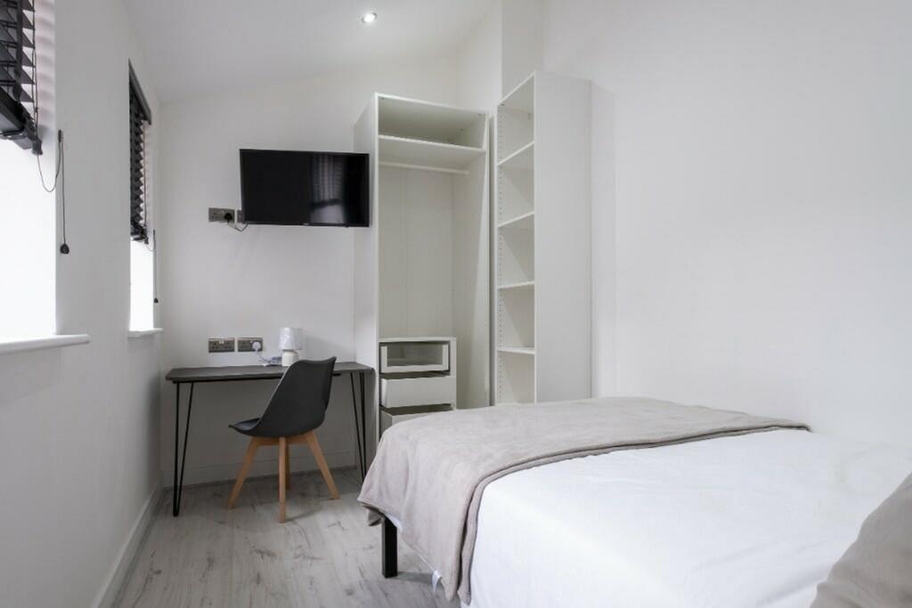 A bright and tidy double bedroom featuring a wo...