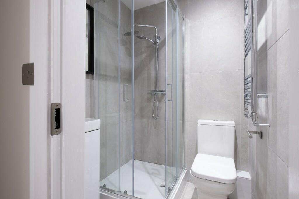 A modern and immaculate bathroom featuring a st...